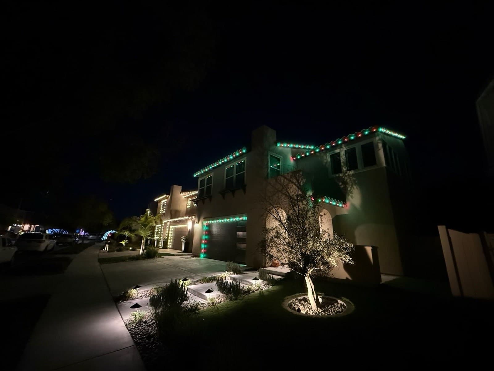 Christmas lights glowing along a San Diego roofline at night